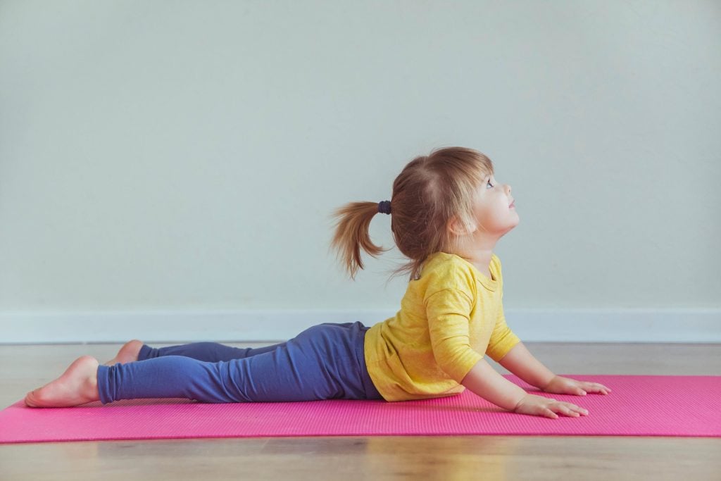 Kleines Mädchen macht Yogaübung