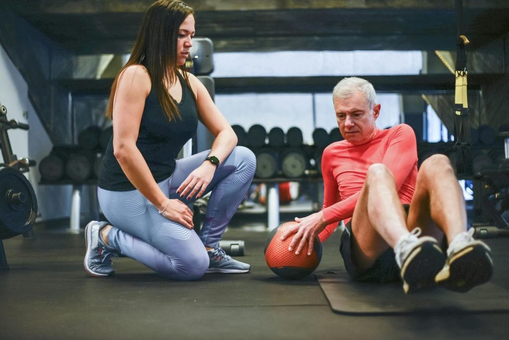 Bauchmuskeltraining, Frau leitet Senior an