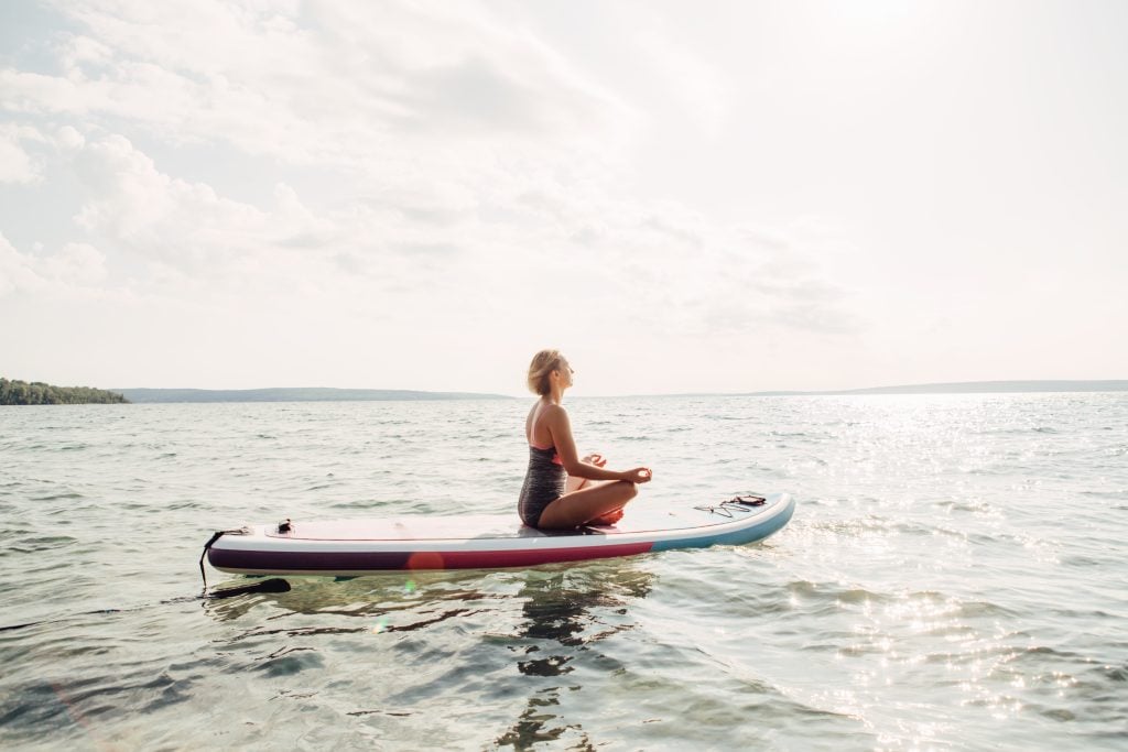 Frau macht Yoga auf SUP