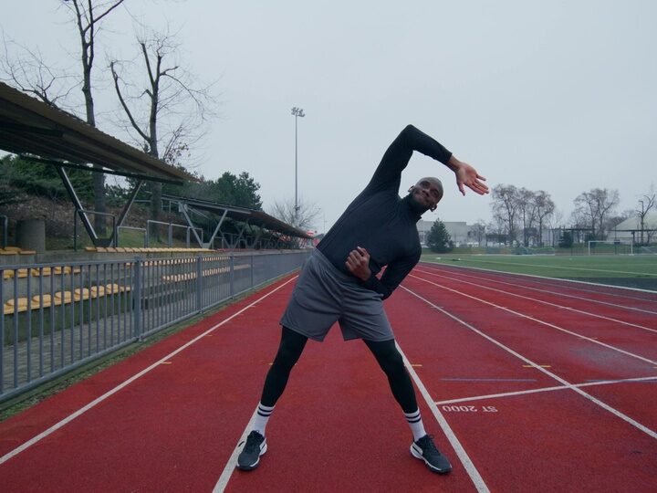 Mann wärmt sich bei kälte im Stadion auf