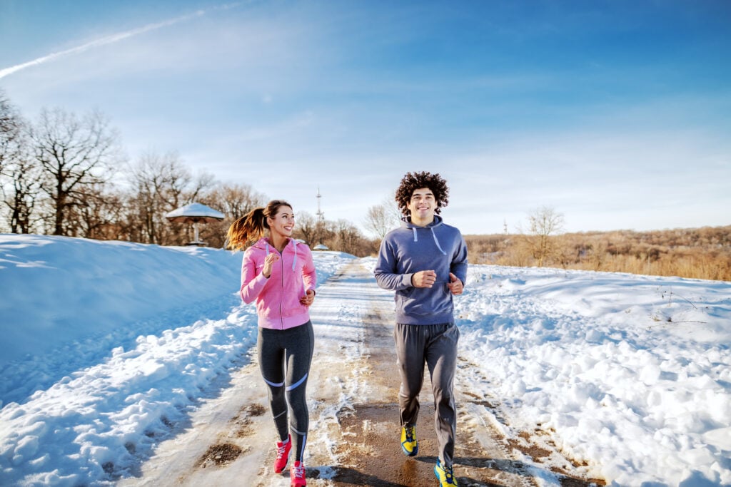 Paar joggt in Winterlandschaft