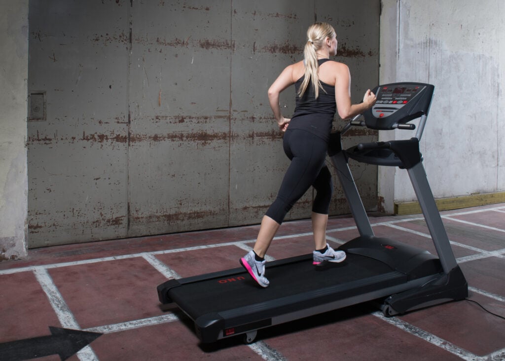 Frau auf Laufband in Industriehalle