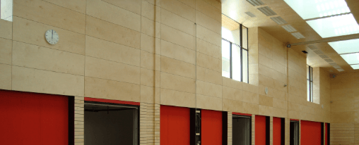 Wanduhr für Sporthalle im Kübler Sport Onlineshop kaufen Wanduhr in einer Sporthalle mit gut ablesbarem Zifferblatt und robuster, ballwurfsicherer Ausführung für Anlagenausstattung im Einsatz