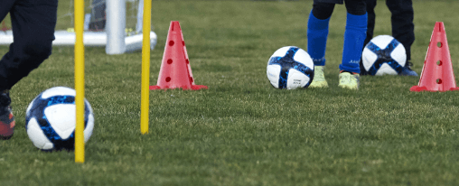 Ball online kaufen bei Kübler Sport Mehrere Ballarten auf einem Sportplatz für Training und Freizeit