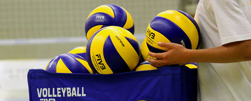 Verschiedene Trainingsbälle Volleyball in unterschiedlichen Größen und Farben auf einem Volleyballfeld