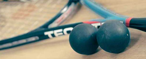 Squashbälle online kaufen im Kübler Sport Onlineshop Verschiedene Squashbälle für Training und Wettkampf, passend für unterschiedliche Spielniveaus, auf einem Spielfeld platziert