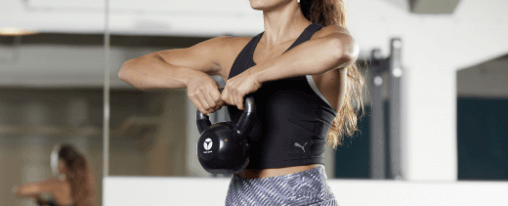 Kettlebell im Kübler Sport Onlineshop kaufen Kettlebell auf Studioboden für funktionelles Training mit robustem Griff und kompaktem Design