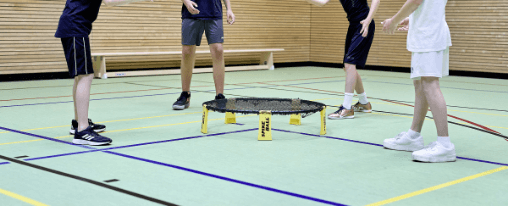 Roundnet online kaufen – Freizeitspaß für Gruppen im Kübler Sport Onlineshop Mehrere Personen spielen Roundnet als Freizeitspiel auf einer Wiese – Netz, Ball und dynamische Bewegung im Einsatz