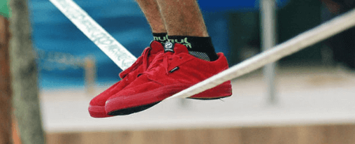 Slackline online kaufen – große Auswahl für Freizeitspiele im Kübler Sport Onlineshop Kinder und Erwachsene balancieren auf einer Slackline im Park – ideales Freizeitspiel für draußen