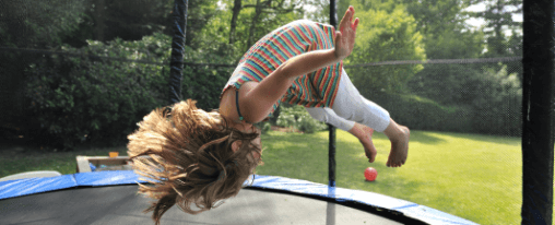 Kinder spielen und hüpfen auf einem sicheren Kindertrampolin im Garten