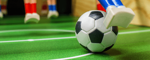 Verschiedene Kickerbälle für Freizeitspiele auf einem Tischkicker
