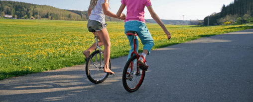 Einrad für Freizeitspiele online kaufen bei Kübler Sport Kinder und Erwachsene fahren Einrad bei Freizeitspielen auf einem Sportplatz