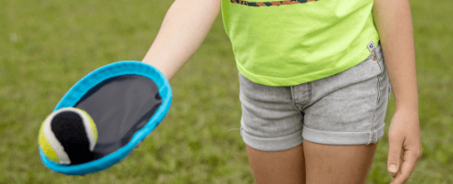 Junges Kind mit dem Wurfspiel Klettball in der Hand