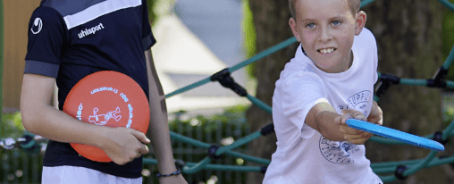 Zwei Schüler auf dem Pausenhof mit Frisbees