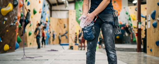 Chalk online kaufen im Kübler Sport Onlineshop Kletterer benutzt Chalk an einer Boulderwand für mehr Griffigkeit und trockene Hände