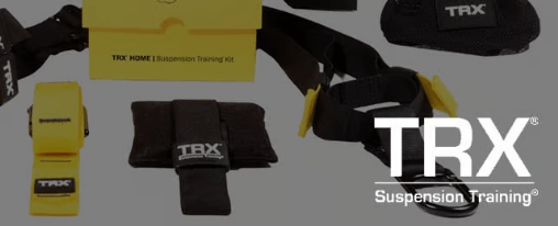 Sportlerin und Sportler beim Training an einem TRX-Schlingentrainer in einer Vereinshalle