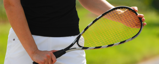 Ein Crossminton-Schl&auml;ger liegt auf einem Spielfeld mit Speedminton-Ball, geeignet f&uuml;r Racketsport und Training.
