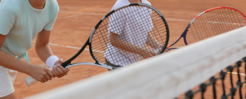 Tennisschläger online kaufen bei Kübler Sport Verschiedene Tennisschläger für Racketsport auf einem Tennisplatz, detailreich präsentiert