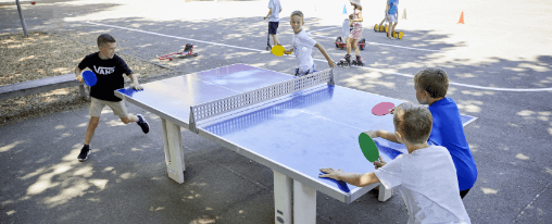 Robuste, wetterfeste Beton Tischtennisplatte f&uuml;r den Racketsport im Au&szlig;enbereich, aufgestellt auf einem Sportplatz