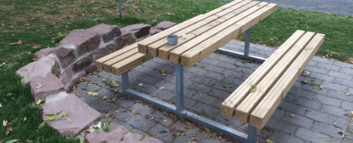 Kinderfreundliche und wetterfeste Tisch Bank Kombination auf einem Spielplatz mit robustem Tisch und integrierten Sitzb&auml;nken