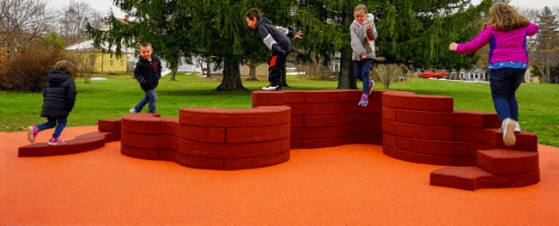 Parkmobiliar online kaufen für Spielplätze und Aufenthaltsbereiche Modernes Parkmobiliar mit Sitzgruppen, Abfallbehältern und Bänken auf einem Spielplatz