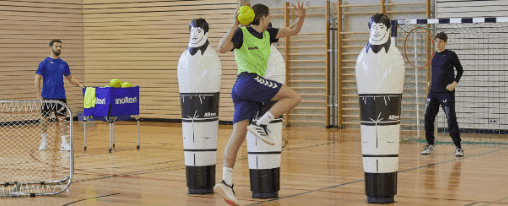 Teamsport-Mannschaft beim Handballtraining mit vielfältigem Handball Zubehör wie Bällen, Markierungshilfen und Trainingsausrüstung in der Sporthalle