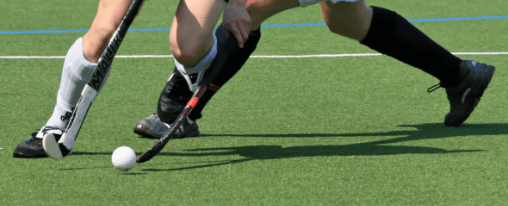 Feldhockeyausrüstung online kaufen für Teamsport im Kübler Sport Feldhockeyshop Teamsportler spielen Feldhockey auf dem Spielfeld mit passender Ausrüstung aus dem Feldhockeyshop