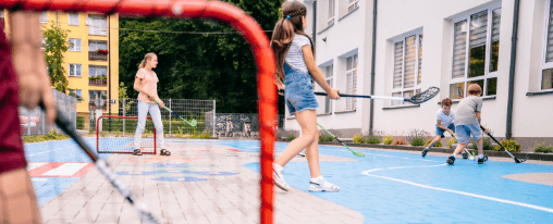 Streethockey Team beim Spiel auf dem Spielfeld mit kompletter Ausrüstung