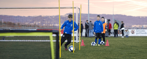 Teamsportbedarf kaufen Fußballteam auf Sportplatz mit gelben Trikots