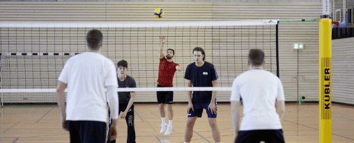 Volleyball-Ausrüstung kaufen Volleyballteams spiele gegeneinander über ein Volleyballnetz