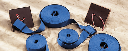 Zubehör für Beachvolleyball im Kübler Sport Onlineshop kaufen Teamsportler spielen Beachvolleyball mit professionellem Zubehör auf einem Sandplatz