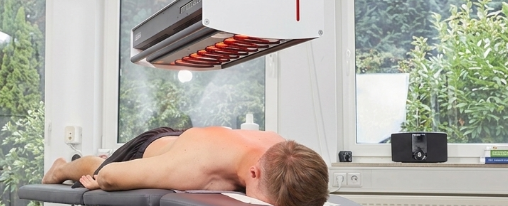 Physiotherapeut verwendet ein physikalisches Therapieger&auml;t bei der Behandlung in einer modernen Praxisumgebung