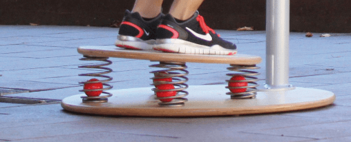 Balance&uuml;bungen mit einem Wackelbrett im Therapiebereich f&uuml;r Gleichgewicht und Koordination