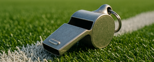 Schiedsrichterpfeife online kaufen – Vereinsbedarf bei Kübler Sport Schiedsrichterpfeife auf Spielfeld mit Trainer und Schiedsrichter im Vereinsbedarf