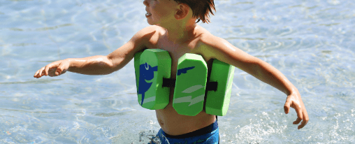 Kind tr&auml;gt einen Schwimmg&uuml;rtel im Wasser w&auml;hrend des Schwimmunterrichts