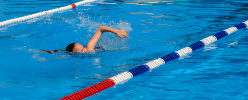 Trennleine online kaufen im Kübler Sport Onlineshop Schwimmende Trennleine zur Bahnabtrennung im Schwimmbecken für Wassersport, aufgenommen in einem modernen Hallenbad