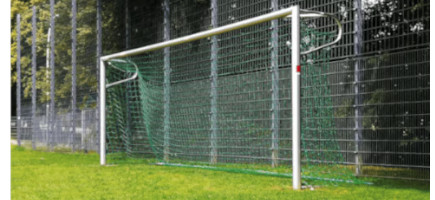 Fest durch Bodenhülsen installiertes Fußballtor mit grünem Netz auf einem Sportplatz