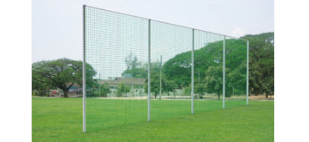 Grünes Ballfangnetz an einem Ballfangzaun eines Sportplatzes