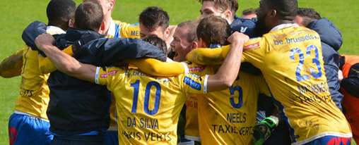 Fußballteam auf Sportplatz mit gelben Trikots