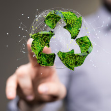 Menschliche Hand zeigt auf ein grünes Recyclingsymbol