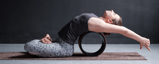 Abbildung eines Yoga Rads im Einsatz zur Unterstützung bei Rückbeugen, Balance-Übungen und für mehr Flexibilität in der Yogapraxis.