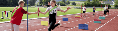 Leichtathletiktraining mit Kindern in Gruppen mit grünen und roten Mannschaftsbändern