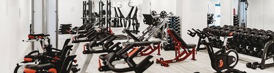 Fitnessstudio ausgestattet mit Cardiogeräten und Hanteln