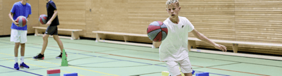 Basketballkorb mit Basketball perspektivisch von unten fotografiert mit Himmel