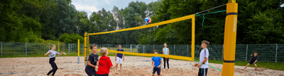 Moderne Beachvolleyballanlage mit Sandfeld, Netz und Spielfeldmarkierungen für professionellen Teamsport