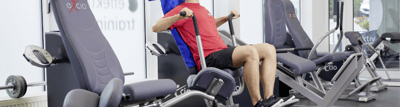 Sportler trainiert im Fitnessstudio an einer Kraftmaschine für die Brust