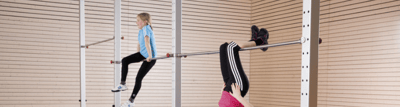 Kinder turnen an einem Turnreck in der Sporthalle