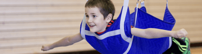 Kind in blauer Kinderturnschaukel
