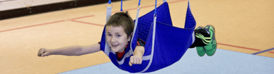 Kind in Kübler Sport Flugschaukel beim Sportunterricht