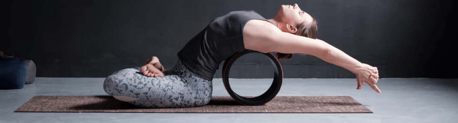 Abbildung eines Yoga Rads im Einsatz zur Unterstützung bei Rückbeugen, Balance-Übungen und für mehr Flexibilität in der Yogapraxis.